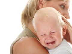 Mother holding her crying baby isolated