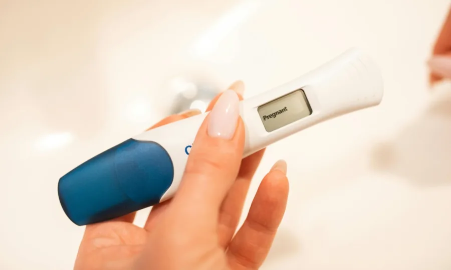 Close-up of a woman holding a positive pregnancy test
