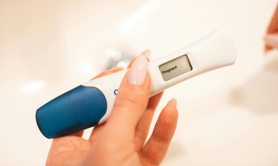 Close-up of a woman holding a positive pregnancy test