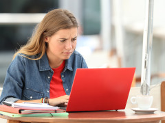 Confused student searching on line with a laptop